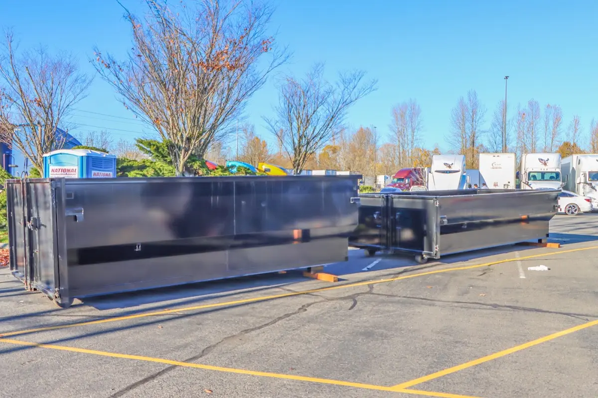 Professional dumpster rental service with roll-off container on residential driveway in Grants Pass